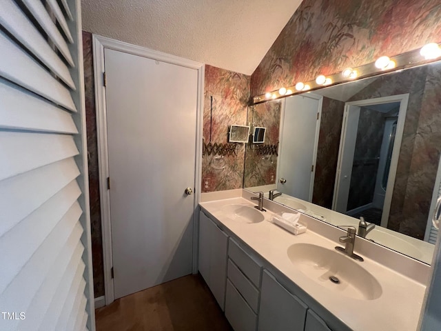 106 Orchard Rd, Henderson, NC 27536 - bathroom with wallpapered walls, a textured ceiling, double vanity, and lofted ceiling