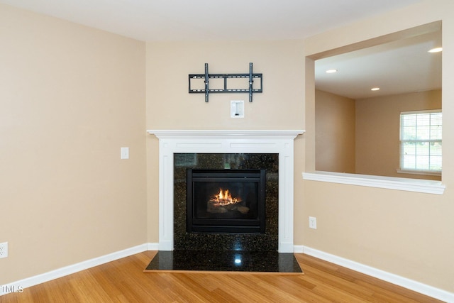 room details featuring wood finished floors, a fireplace, and baseboards