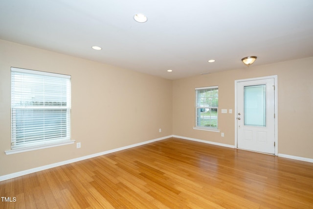 unfurnished room featuring light wood-style floors, baseboards, and recessed lighting