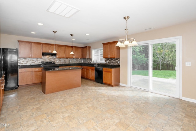 kitchen with tasteful backsplash, exhaust hood, dark countertops, black appliances, and a sink