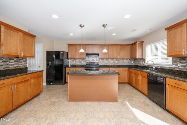 kitchen with a center island, brown cabinets, dark stone counters, black appliances, and ventilation hood