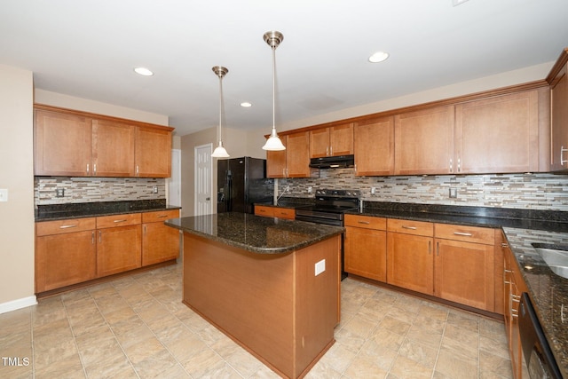 kitchen with stainless steel range with electric cooktop, under cabinet range hood, freestanding refrigerator, and brown cabinetry