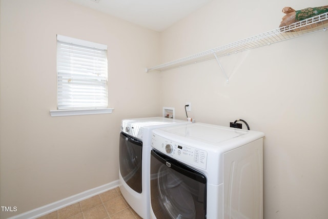 laundry room with light tile patterned floors, baseboards, washing machine and dryer, and laundry area