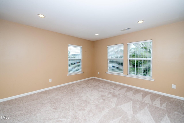 carpeted empty room featuring baseboards, visible vents, and recessed lighting