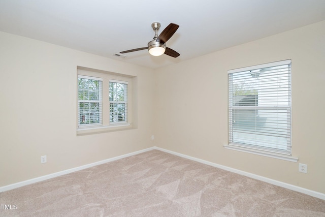 spare room featuring baseboards, a ceiling fan, visible vents, and carpet floors