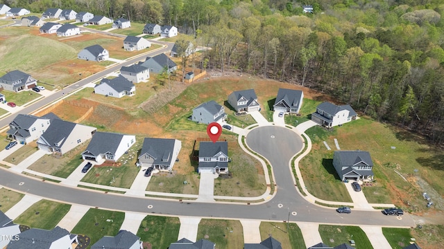 drone / aerial view featuring a wooded view and a residential view