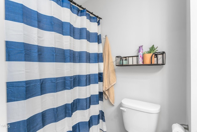 full bathroom featuring toilet and a shower with shower curtain