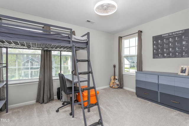 carpeted bedroom featuring baseboards, multiple windows, and visible vents