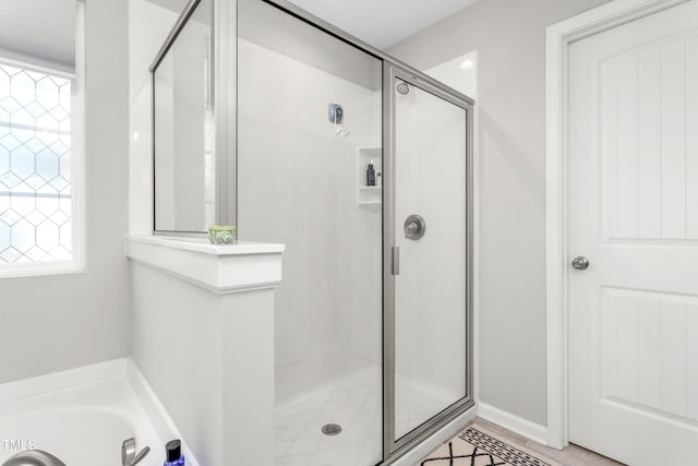 bathroom with a bath and a stall shower