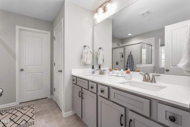 full bathroom featuring double vanity, visible vents, a sink, and a stall shower