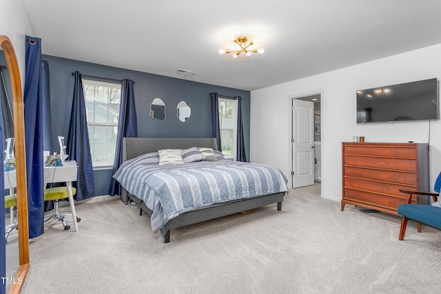 carpeted bedroom featuring a chandelier, visible vents, and baseboards
