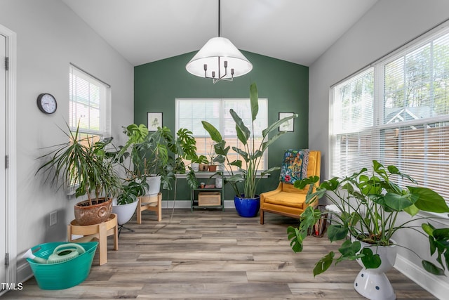 living area with baseboards, vaulted ceiling, and wood finished floors