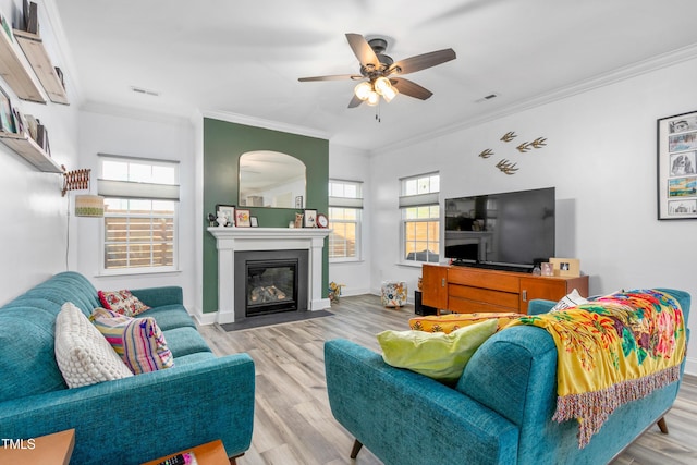 living area featuring crown molding, wood finished floors, and ceiling fan