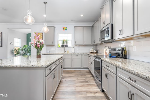kitchen with stainless steel appliances, gray cabinetry, tasteful backsplash, and ornamental molding