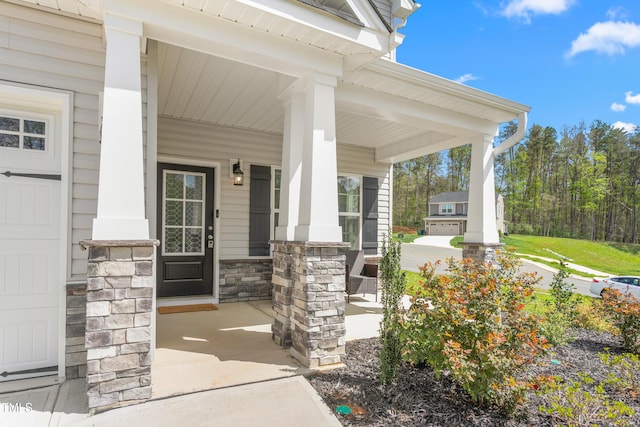entrance to property with a porch and stone siding