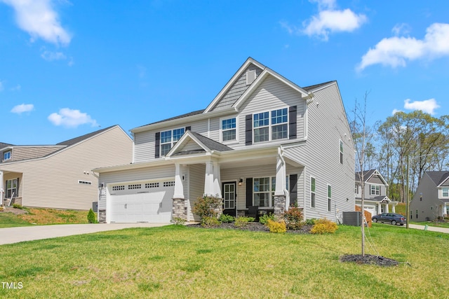 craftsman house with concrete driveway, a front yard, stone siding, and central AC