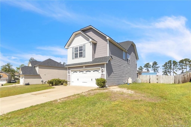 view of front of property featuring a front yard, driveway, fence, and an attached garage
