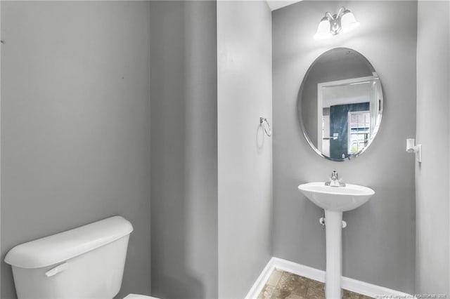 bathroom featuring toilet and baseboards