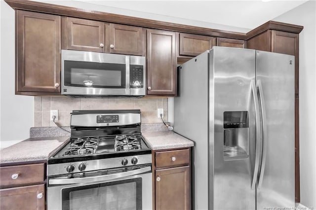 kitchen with stainless steel appliances, light countertops, and backsplash
