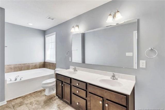 bathroom featuring a bath, double vanity, visible vents, and a sink