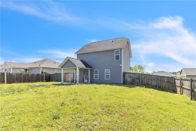 rear view of property with a yard and a fenced backyard