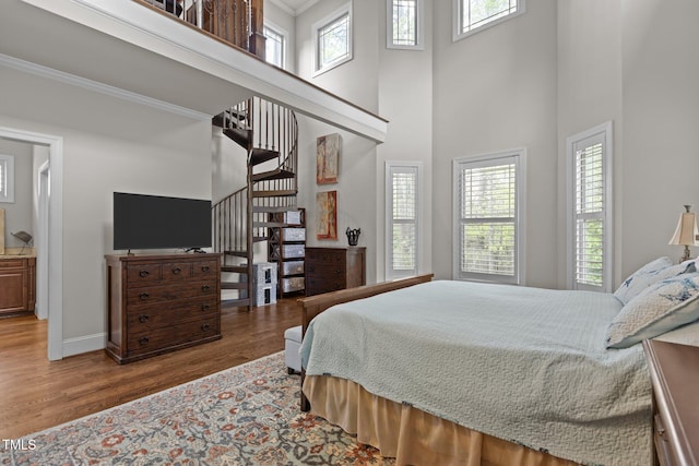 1512 Piazzo Ct, Apex, NC 27502 - bedroom featuring wood finished floors, a towering ceiling, baseboards, and crown molding