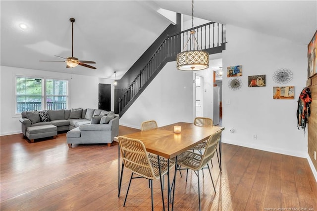 dining space featuring stairs, wood-type flooring, baseboards, and ceiling fan