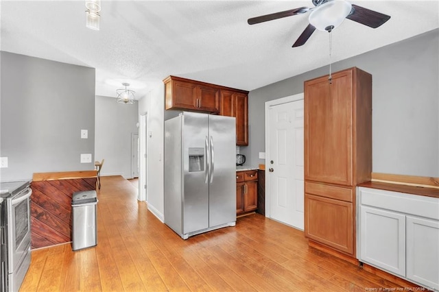 kitchen with stainless steel appliances, light wood-style floors, light countertops, and ceiling fan