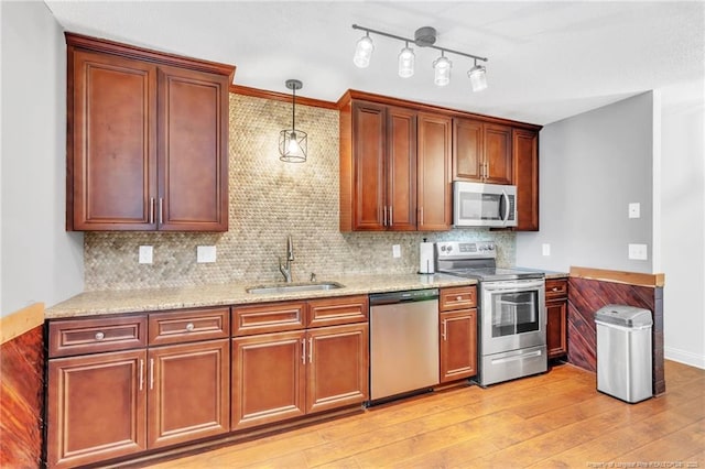 kitchen featuring a sink, backsplash, light wood-style floors, and stainless steel appliances