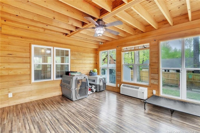 sunroom with beamed ceiling and a wall mounted AC
