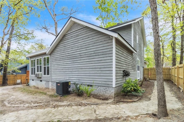 view of property exterior featuring crawl space, cooling unit, and a fenced backyard