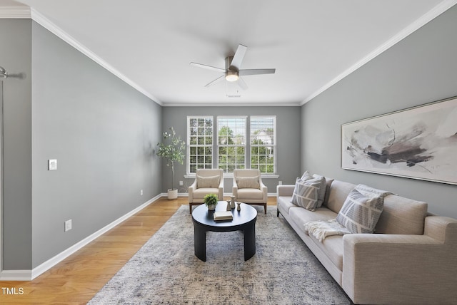 living room featuring ornamental molding, ceiling fan, light wood finished floors, and baseboards