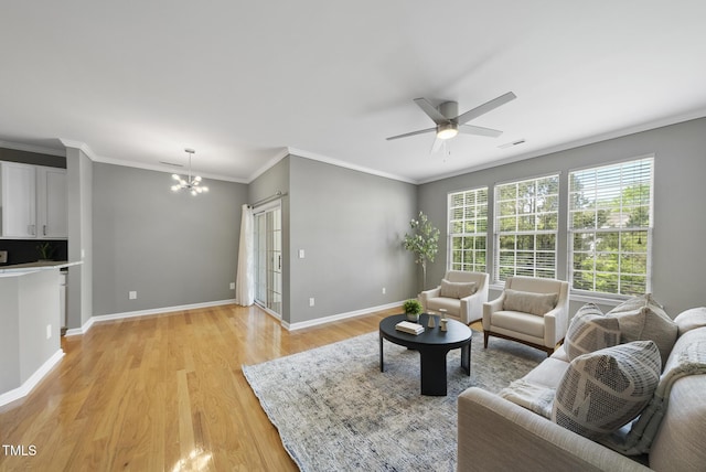 living area with light wood-style floors, baseboards, crown molding, and ceiling fan with notable chandelier