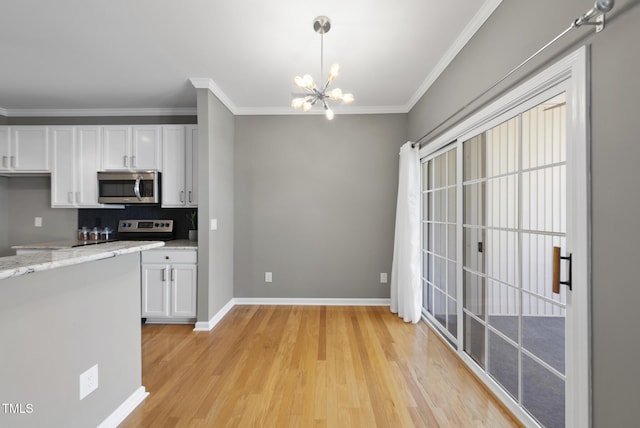 kitchen with baseboards, a chandelier, white cabinetry, crown molding, and appliances with stainless steel finishes