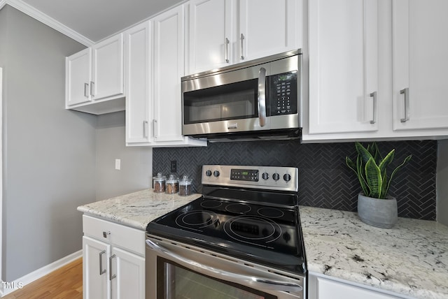 kitchen featuring white cabinets, baseboards, and stainless steel appliances