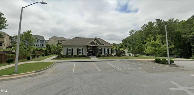 view of front of property featuring uncovered parking and fence
