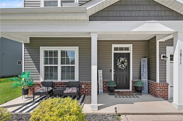 property entrance with brick siding and a porch