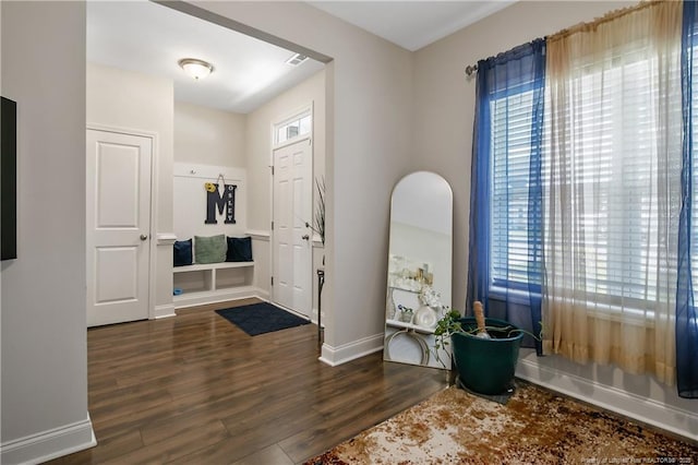 entryway featuring visible vents, baseboards, and wood finished floors
