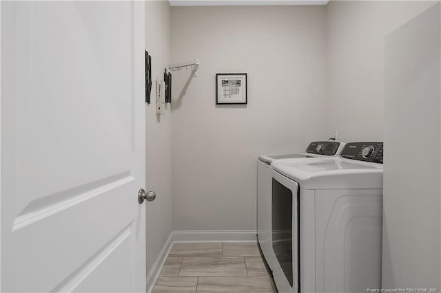 laundry room featuring baseboards, washer and clothes dryer, and laundry area
