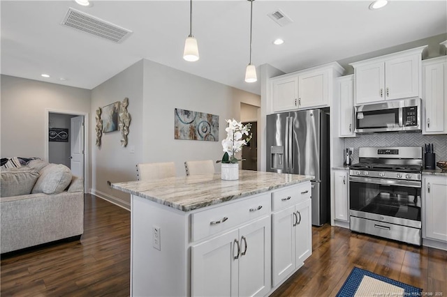 kitchen featuring visible vents, open floor plan, appliances with stainless steel finishes, and dark wood-style floors