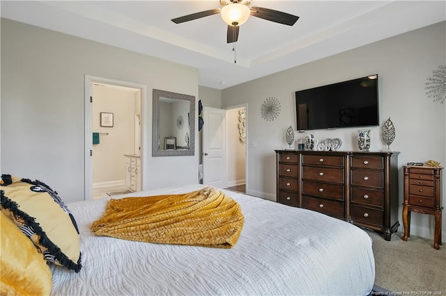 bedroom featuring baseboards, a raised ceiling, connected bathroom, carpet floors, and ceiling fan