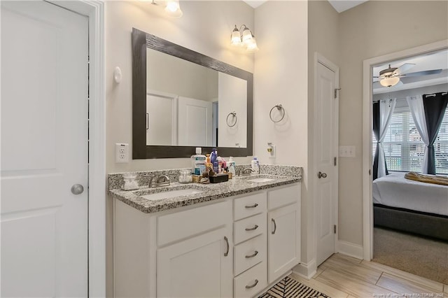 full bath with a sink, baseboards, double vanity, and a ceiling fan