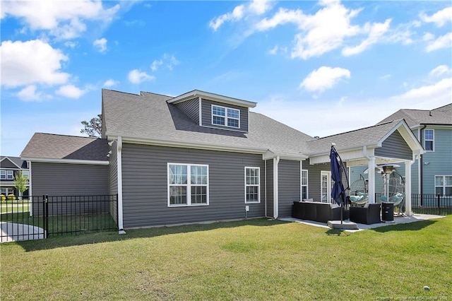 back of house with a yard, an outdoor living space, fence, and a shingled roof