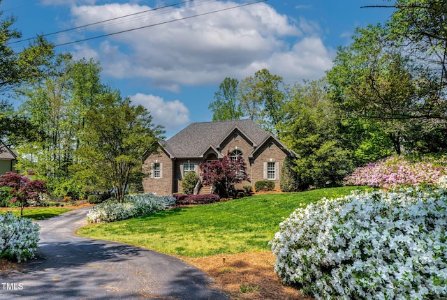 955 Sagamore Dr, Louisburg, NC 27549 - view of front facade featuring aphalt driveway, a shingled roof, a front lawn, and brick siding