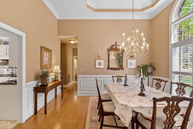955 Sagamore Dr, Louisburg, NC 27549 - dining room with a notable chandelier, light wood-style floors, ornamental molding, and a wainscoted wall