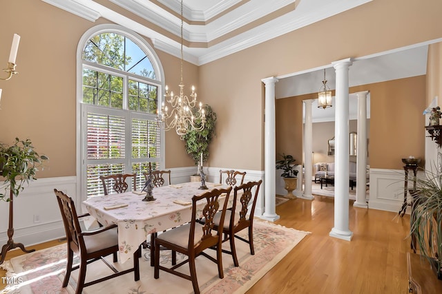955 Sagamore Dr, Louisburg, NC 27549 - dining room with a decorative wall, crown molding, ornate columns, wainscoting, and light wood-style flooring