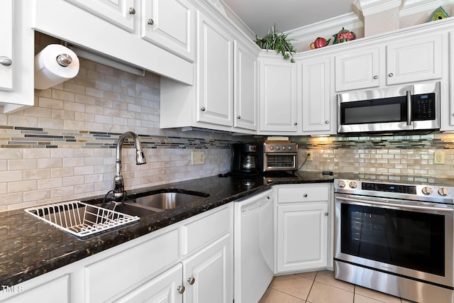 955 Sagamore Dr, Louisburg, NC 27549 - kitchen with light tile patterned floors, appliances with stainless steel finishes, crown molding, white cabinetry, and backsplash