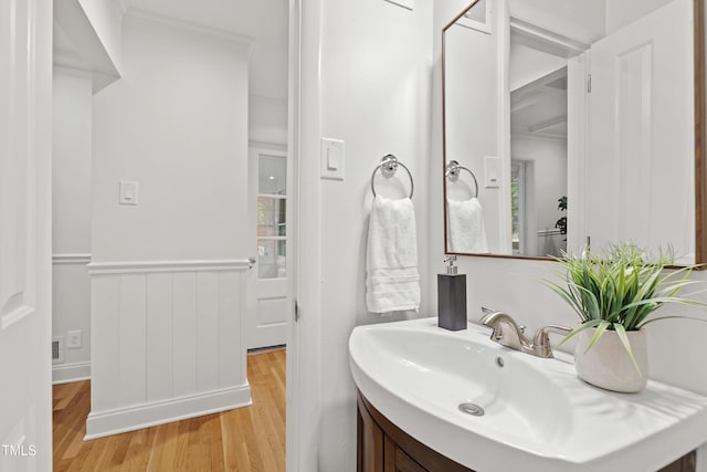4902 Brookhaven Dr, Raleigh, NC 27612 - bathroom featuring wood finished floors, vanity, ornamental molding, and wainscoting