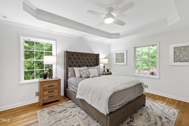 4902 Brookhaven Dr, Raleigh, NC 27612 - bedroom with a raised ceiling, crown molding, multiple windows, wood finished floors, and a ceiling fan