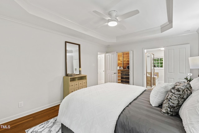 4902 Brookhaven Dr, Raleigh, NC 27612 - bedroom with a tray ceiling, ornamental molding, dark wood-style floors, baseboards, and ensuite bath